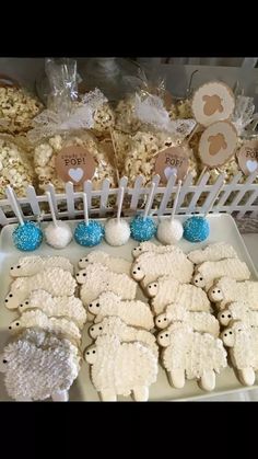 there are many cookies on the table with blue and white candies in front of them