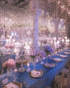 a table is set with blue linens and flowers