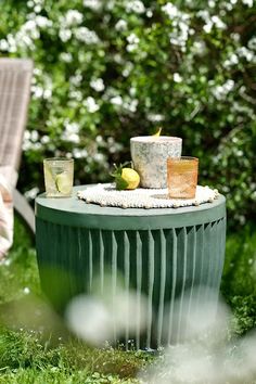 two cups are sitting on top of a green table in the middle of some grass