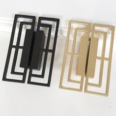 three different types of metal door handles on a white surface, one black and one gold