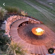 an outdoor fire pit surrounded by rocks and wood