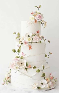 a three tiered white wedding cake with flowers on it