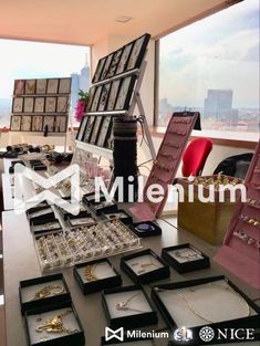 a table with jewelry on it in front of a large window and cityscape