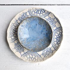 a blue and white plate sitting on top of a wooden table next to a wall