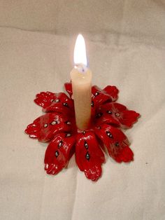 a lit candle with red flowers on it