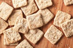 some crackers are sitting on a wooden cutting board and ready to be cut into bite sized pieces