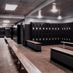 an empty locker room with benches and lights