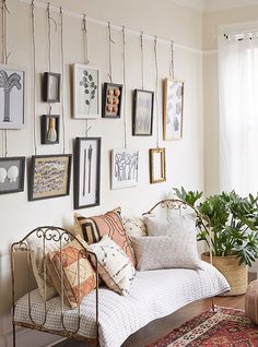 a living room filled with lots of pictures on the wall above a couch and coffee table