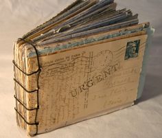 an old book with writing on it sitting on top of a white cloth covered table