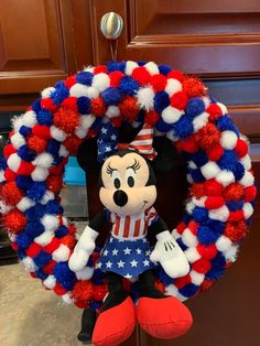 a mickey mouse wreath with red, white and blue pom - poms on it