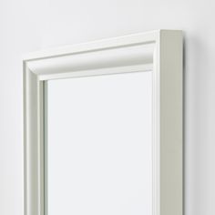 a white framed mirror mounted on the wall