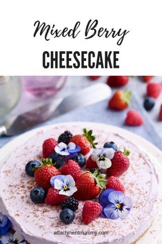 a close up of a cake on a plate with berries and blue flowers around it