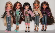 five dolls are lined up in the same row, one is wearing jeans and the other has long hair