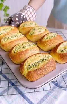 freshly baked breads are lined up on a baking sheet for serving to the guests