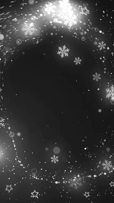 snowflakes and stars are flying in the air on a black background with white lights