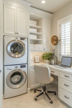 a washer and dryer are in the corner of this white laundry room with built - in shelving