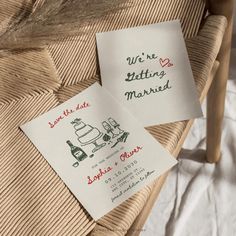 two wedding cards with the words we're getting married on them sitting on a wicker chair