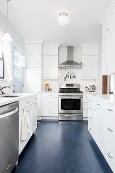 a kitchen with white cabinets and stainless steel appliances