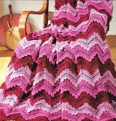 a crocheted blanket sitting on top of a wooden chair