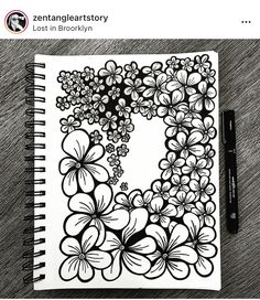 a black and white drawing of flowers in the shape of a letter d on top of a wooden table