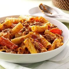 a white bowl filled with pasta and meat