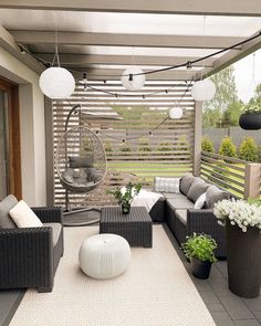 an outdoor living area with wicker furniture and plants