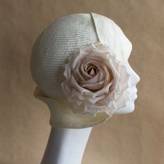 Emilia Cloche Hat. Stylish cloche by And They Loved Hats in off white straw with ivory/beige silk rose. This hat features an eyecatching sculpted tuck brim and an intricate side pleated asymmetric art deco style side brim. Perfect for Summer gatherings and evening soirees.  YOUR SIZE inches or centimeters 21" | 53-54cm 21.5" | 54-55cm 22" | 56cm 22.5" | 57-58cm 23" | 58-59cm 23.5" | 60cm Place a tape measure on your forehead just above the eyebrow. Fit it around your head, ensuring that the wide Elegant Hat With Structured Crown In Natural Color, Elegant Natural Hat With Structured Crown, Fitted Cream Straw Hat With Curved Brim, Cream Sun Hat For Spring Wedding, Adjustable Cream Sun Hat For Wedding, Beige Sun Hat With Short Brim For Wedding, Cream Cloche Fascinator For Summer, Adjustable Cloche Hat For Spring Wedding, Adjustable Brimmed Straw Hat For Wedding