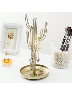 there is a gold jewelry holder with pearls and other items on the table next to it