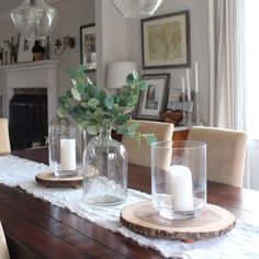 a wooden table topped with vases and candles