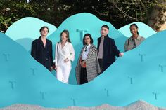 four people standing in front of a blue wall with the letter t cut out into it