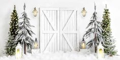 christmas trees and lanterns in front of a barn door