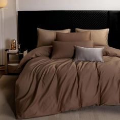 a bed with brown sheets and pillows in a room