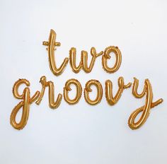 two groovy balloons in the shape of letters on a white surface with one balloon that says two groovy