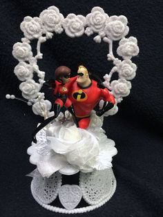 a wedding cake topper made to look like the bride and groom are kissing in front of a heart shaped frame