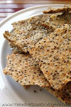 some crackers are on a white plate with brown speckles and black dots