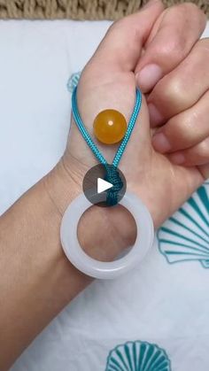 a person is holding two bracelets with beads on them and an orange bead around the wrist