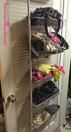 an organized closet with shoes and purses on the shelves, in front of a door