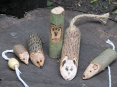 five carved wooden animals on top of a tree stump next to two roped ends