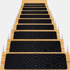 a set of stairs with black carpet and wooden steps leading up to the top one