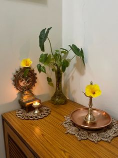 two vases with yellow flowers on a wooden table