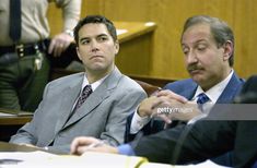 two men in suits sitting at a table