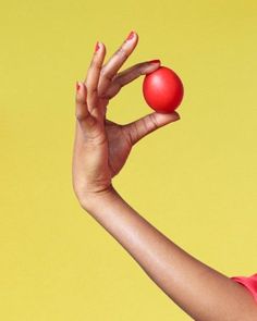 a woman holding two red balls in one hand and an orange ball in the other