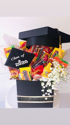 a graduation gift box filled with candy, candies and other snacks on a plate