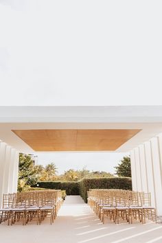 an outdoor wedding venue with rows of chairs and tables set up in front of the entrance