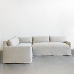 a large white couch sitting on top of a cement floor next to a lamppost