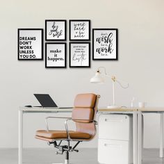 a white desk topped with a laptop computer next to a wall mounted art work quote