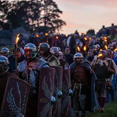 a large group of people dressed in medieval costumes and helmets, standing next to each other