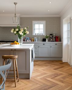 a kitchen with white cabinets and wooden floors