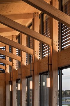 the inside of a building with wooden beams and windows on both sides, along with large sliding glass doors