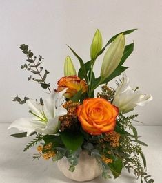 a vase filled with orange and white flowers